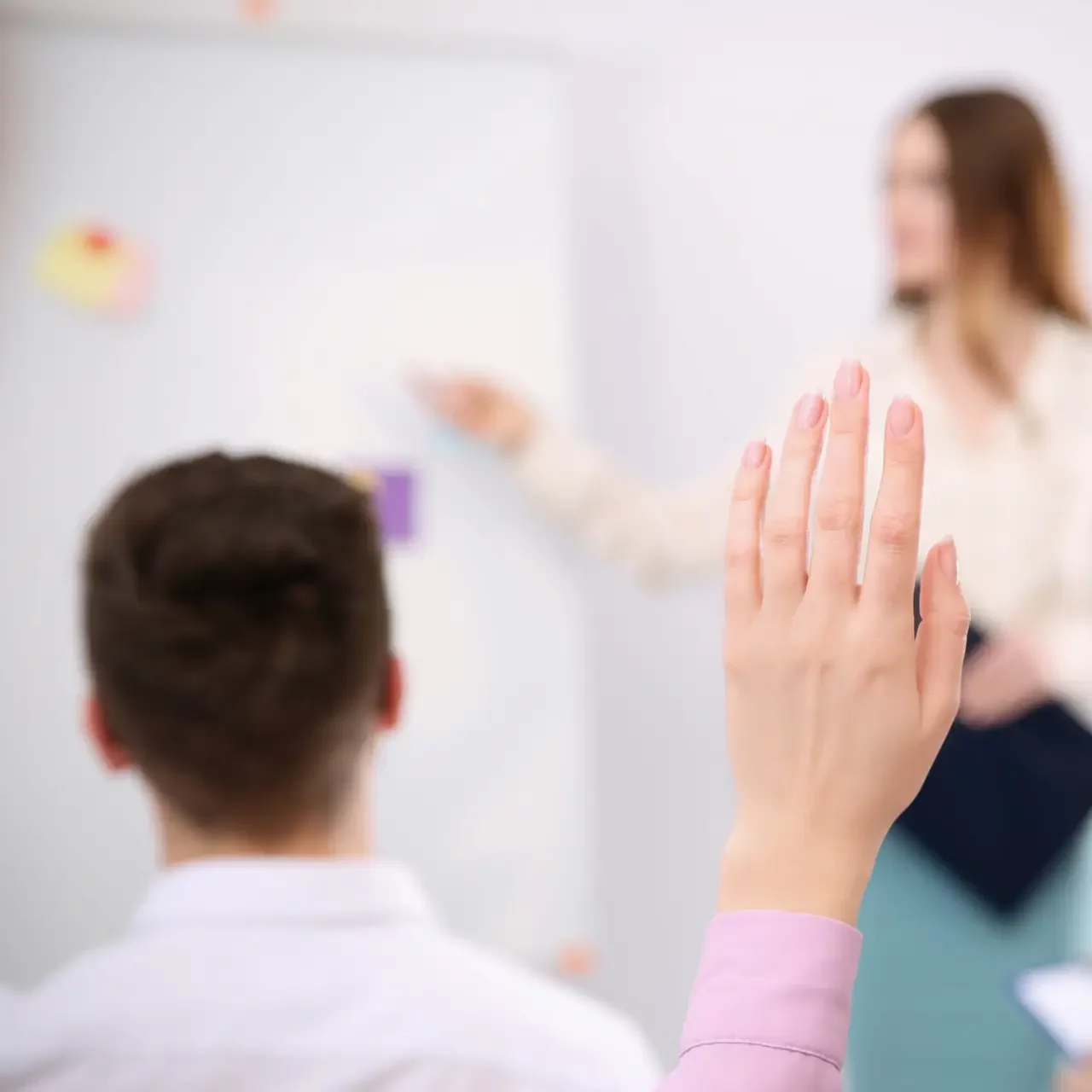 Woman raising hand to ask question at business training indoors, closeup